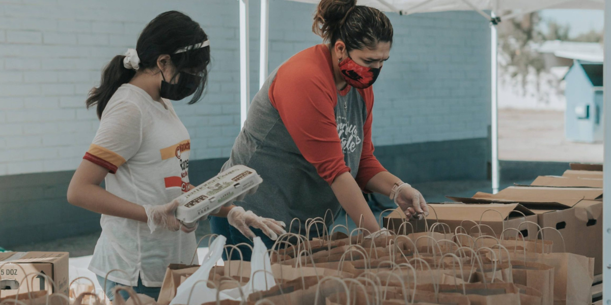 Two women volunteers packing bags for food bank