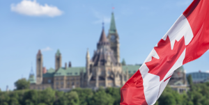 Canadian flag with parliamentary building in the background